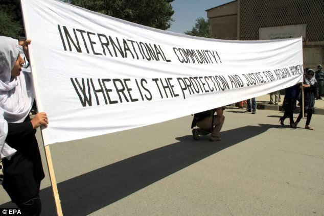 English banners: Choosing an international language to voice their protest, the banner reads, 'International community! Where is the protection and justice for Afghan women?' 
