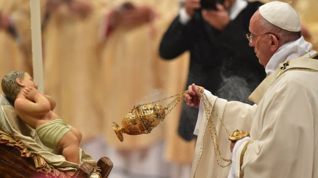 Pope Francis swings a censer in front of a statue of baby Jesus as he celebrates a mass on Christmas eve marking the birth of Jesus Christ on December 24, 2015