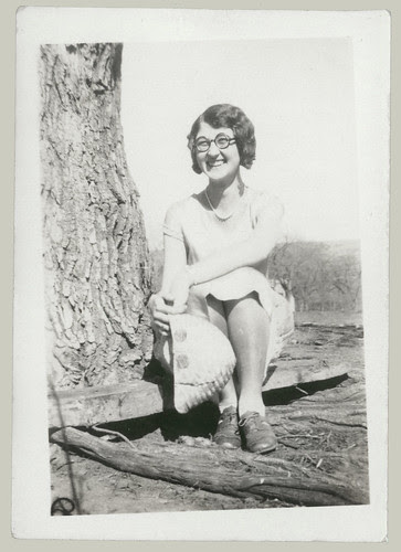 Girl sitting on log.