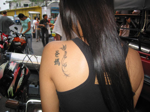 His “believe in yourself” graffiti ribcage tattoo is also visible.