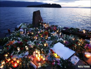 Flowers and candles commemorate the victims on the lake shore facing Utoeya island, Norway, 26 July      
