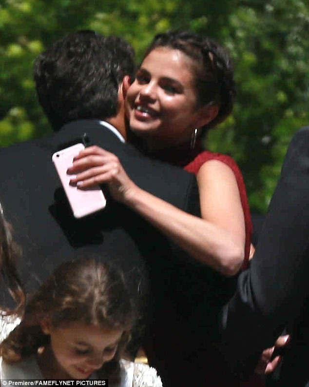 Hugs: Here she embraced a pal as she held onto her cell phone