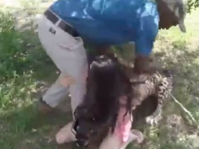 The animal held on tightly as the park staff member struggled to get it off. Picture: Youtube.