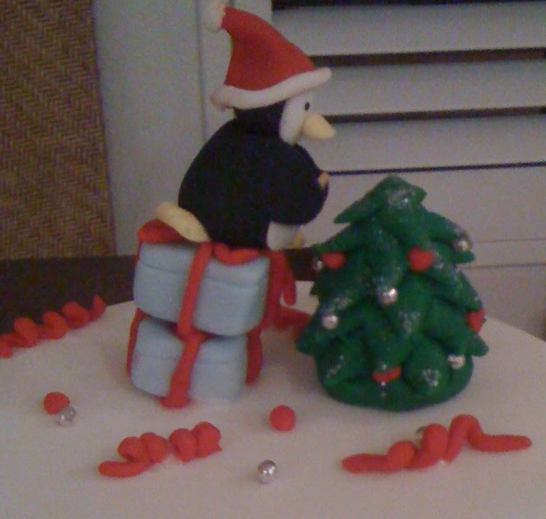 Cake with penguin reaching to put star on Christmas tree