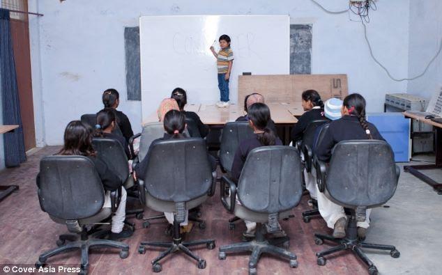Azad Shing mengajar. Karena badannya pendek, maka dia berdiri di atas meja saat menerangkan pelajaran ilmu komputer.