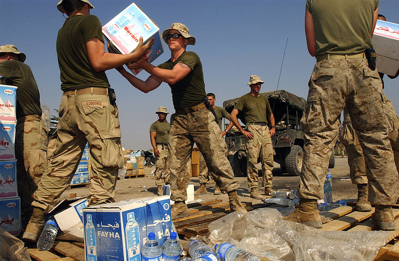 Fuzileiros navais norte-americanos carregando caixas com garrafas de água para assistência humanitária durante a Operação Sweeney, na península de Al Faw, no Iraque (foto: U.S. Navy/Wikimedia Commons)