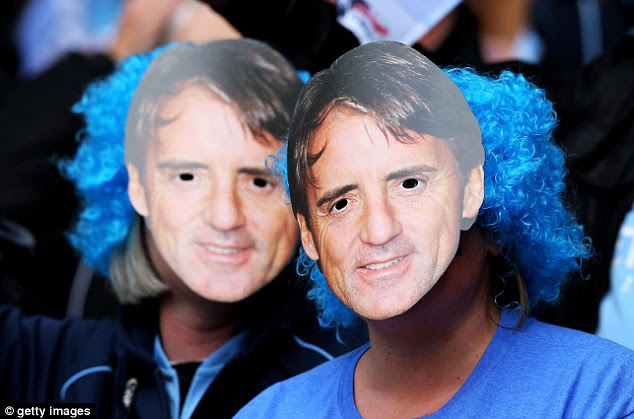 Support: Two Manchester City fans wear Mancini masks at Wembley