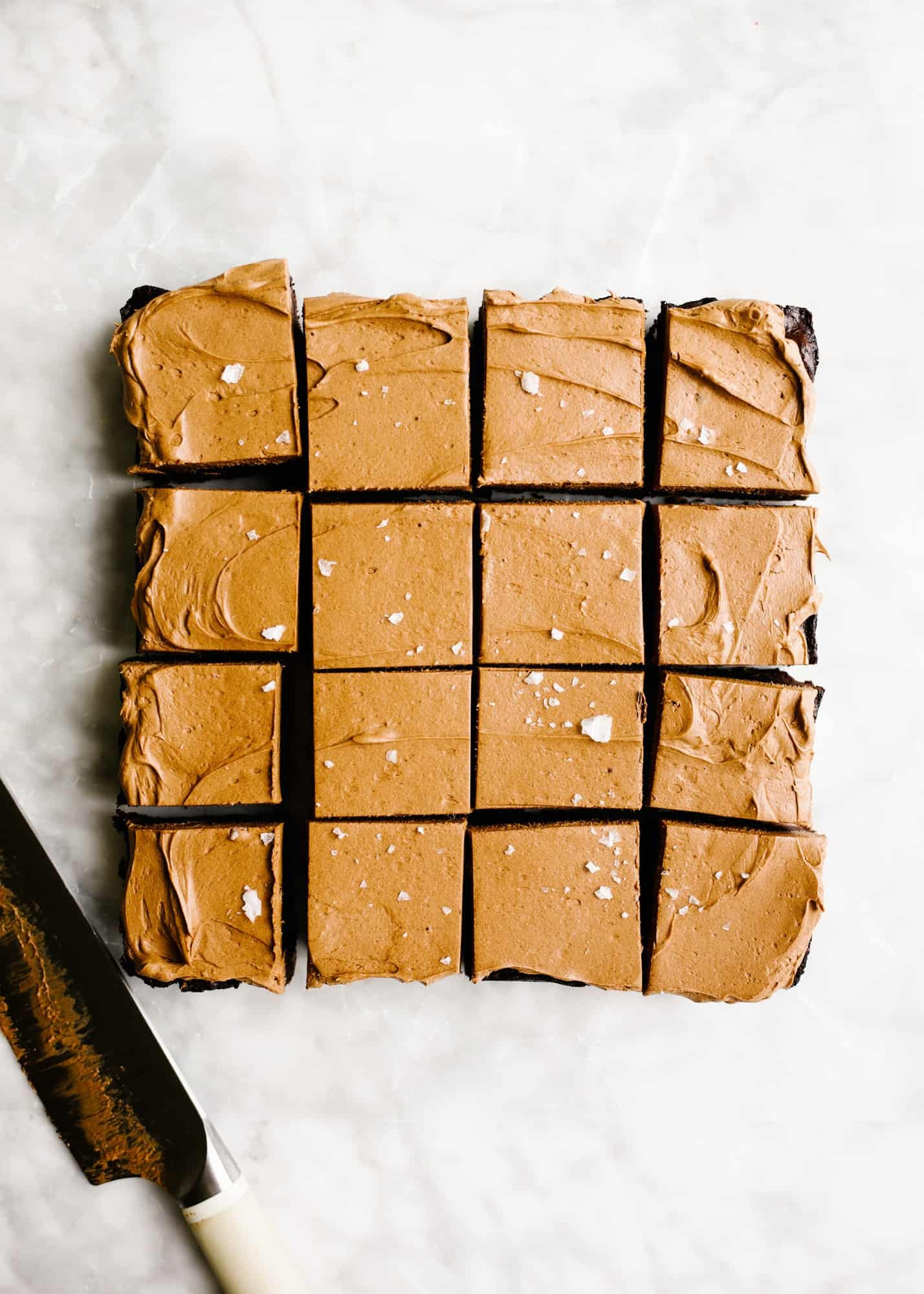 Caramel Ganache Brownies by Wood and Spoon. These are intensely chocolatey bars with a whipped caramel chocolate ganache topping and flaked sea salt. These brownies are made with butter, chopped chocolate, and just enough sugar for balance. The result is a dense and rich treat that is a perfect dessert all year round. Learn how to make these bars for a crowd on thewoodandspoon.com