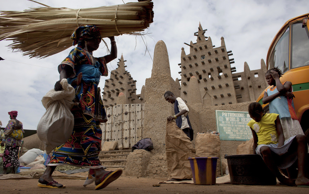 A woman walks by the Grand Mosque of Djenne on market day in Djenne, Mali, on Sept. 2. The UNESCO World Heritage-listed town is among the Malian tourist sites suffering from a huge drop in visitors after a coup took place in March and Islamist rebels seized control of the country's north.