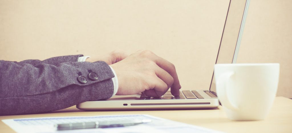 A man types on a laptop keyboard