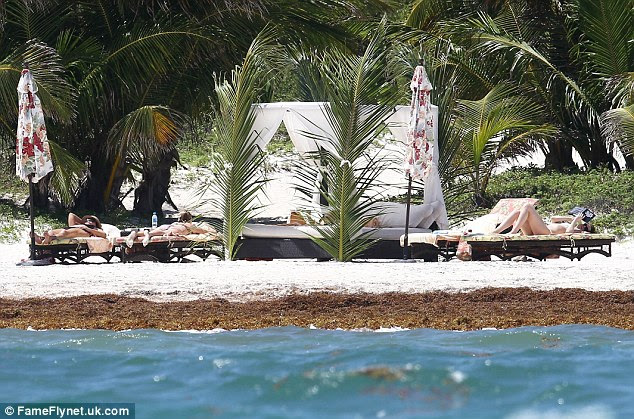 Tropical paradise: The trio had the use of a day bed for some shade as well as four sun loungers