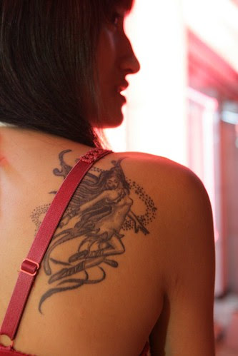 Beautiful woman with tattoo angel at hinder   