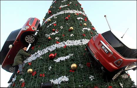 A Chinese worker decorates a Christmas tree with mock Mini Cooper cars