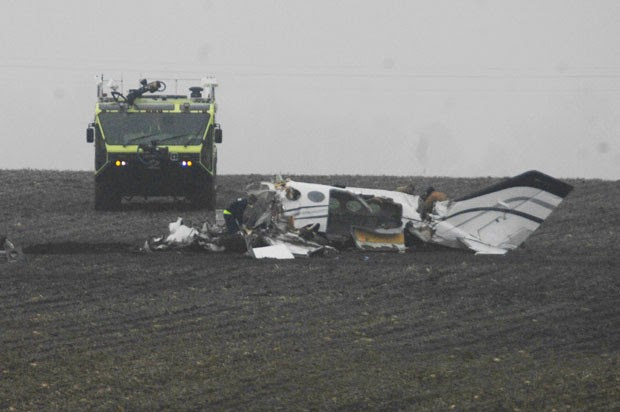 Investigadores trabalham no local da queda de um avião de pequeno porte em Illinois, nos EUA; as sete pessoas a bordo morreram (Foto: The Pantagraph, David Proeber/AP)