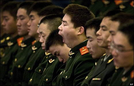 Chinese paramilitary police officers doze at the Great Hall of the People in Beijing