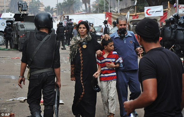 Young and old: Supporters of ousted Islamist President Mohammed Morsi walk through their sit-in camp as Egyptian security forces clear the sit-in camp set up near Cairo University in Cairo's Giza district