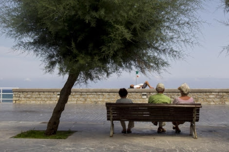 Ancianos sentados en un banco junto al Kursaal, en San Sebastián.
