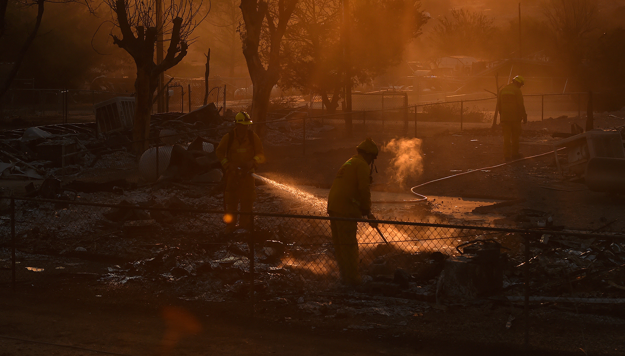 Firefighters mop-up a hot spot  at a residence levelled by the Erskine Fire in South Lake, California, USA