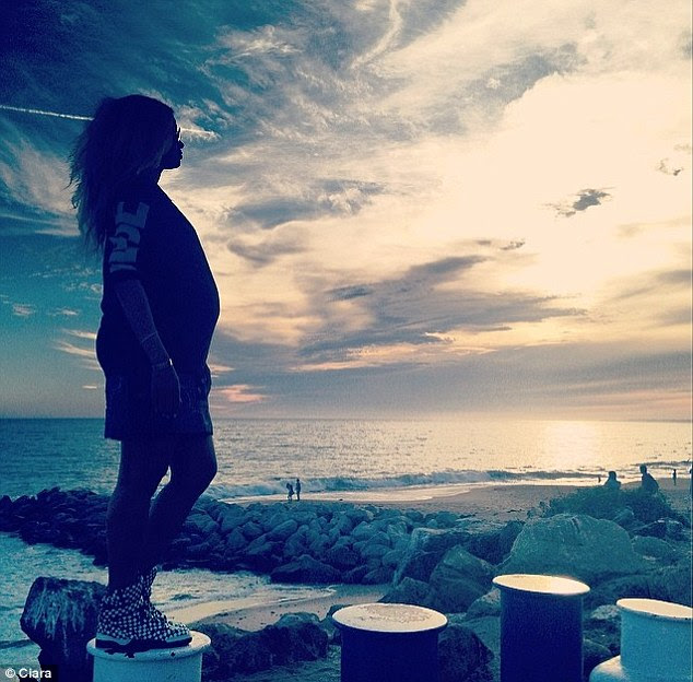 Sunset drama: Ciara posted a picture on Monday of her showing off her bump against the fading sky