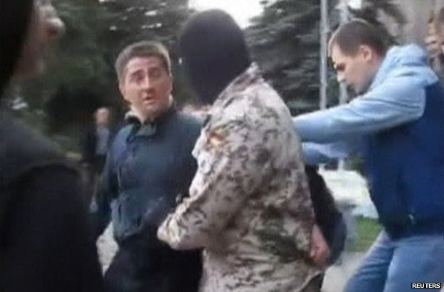 Video grab showing Volodymyr Rybak being manhandled by a masked man outside Horlivka town hall, 17 April