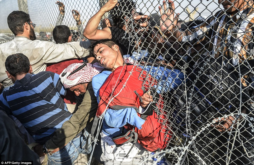 Syrian refugees waiting on the Tal Abyad border cheered in delight as they heard that Kurdish forces were making headway towards the ISIS-held town before attempting to battle through the barbed wire which separates Syria from Turkey as they desperately tried to flee