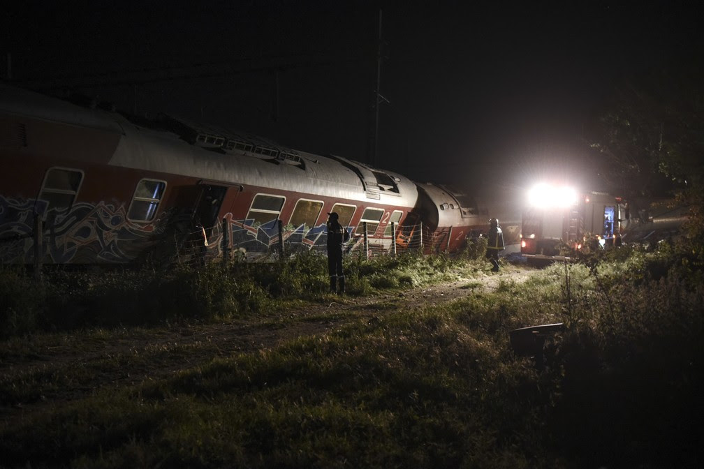 Equipes de resgate trabalham entre os destroços do trem que descarillou na Grécia neste sábado (13) (Foto: Giannis Papanikos/AP)