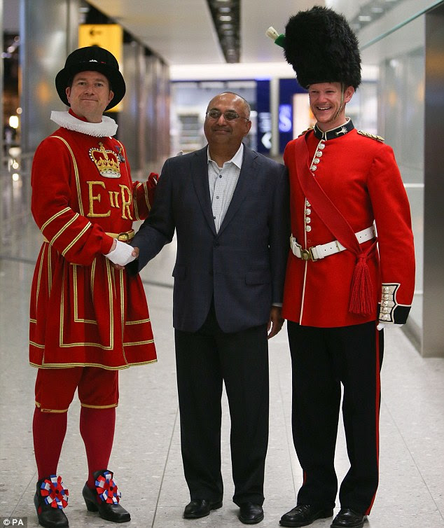 Warm welcome: One of the first passengers to arrive at Heathrow's Terminal 2, Mohan Rao, is greeted by staff dressed as a Yeoman Warder and Beefeater