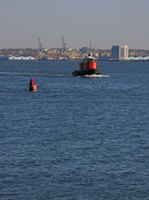 small red tugboat on the Hudson River, NYC