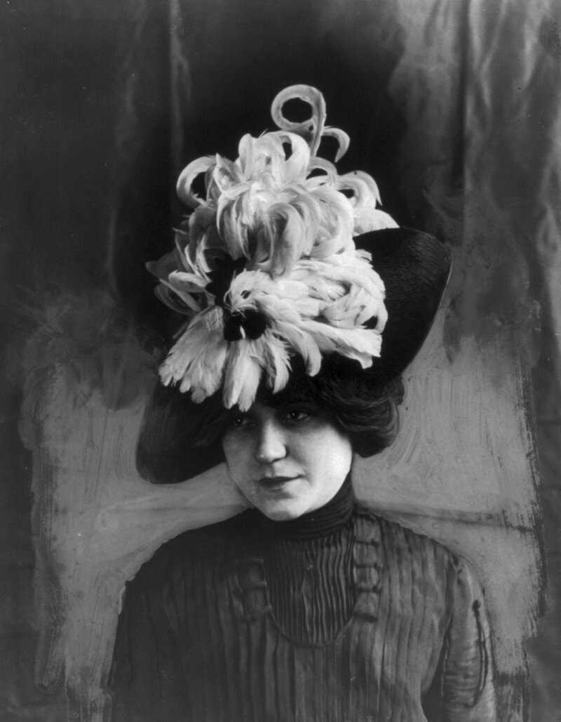 Woman wearing a "Chanticleer" hat made of bird feathers, circa 1912.