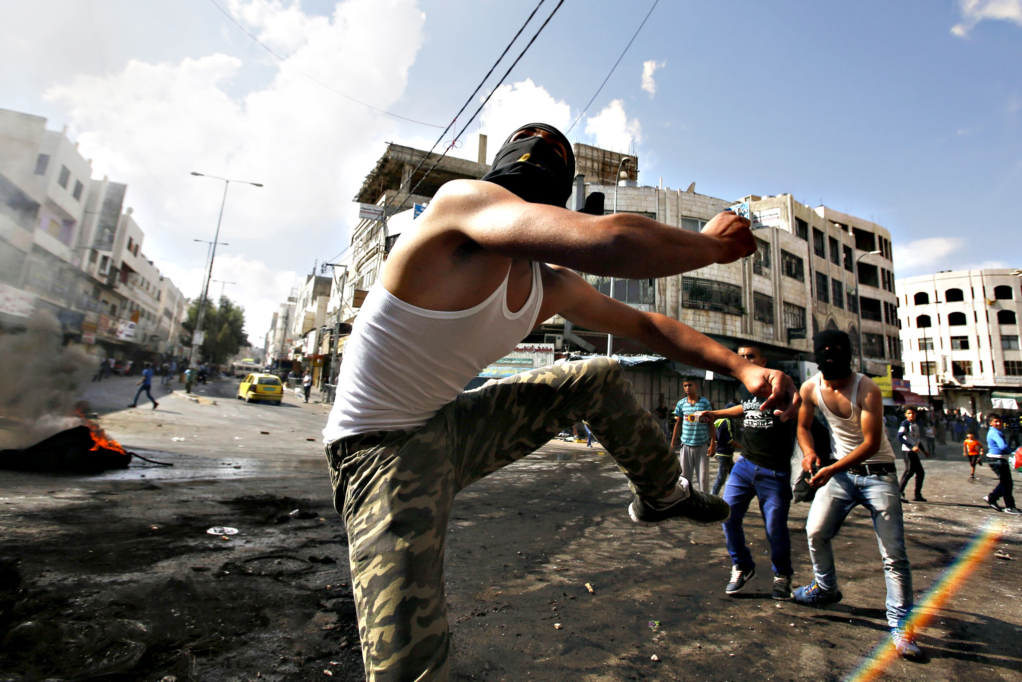 Palestinian protesters throw stones at Israeli troops during clashes over tension in Jerusalem's al-Aqsa mosque, in the occupied West Bank city of Hebron...Palestinian protesters throw stones at Israeli troops during clashes over tension in Jerusalem's al-Aqsa mosque, in the occupied West Bank city of Hebron September 29, 2015. Israeli police and Palestinians clashed on Sunday at Jerusalem's al-Aqsa mosque compound, where violence in recent weeks has raised international concern. 