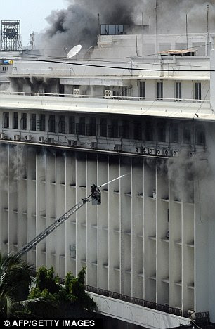 Hard task: Firefighters spray jets at the blaze from a hydraulic 
platform