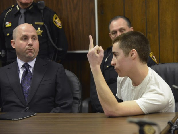 O réu T.J. Lane faz gesto obsceno a familiares das vítimas dos ataques em Ohio, durante seu julgamento por três mortes em ataque à escola Chardon (Foto: The News-Herald, Duncan Scott, Pool/AP)