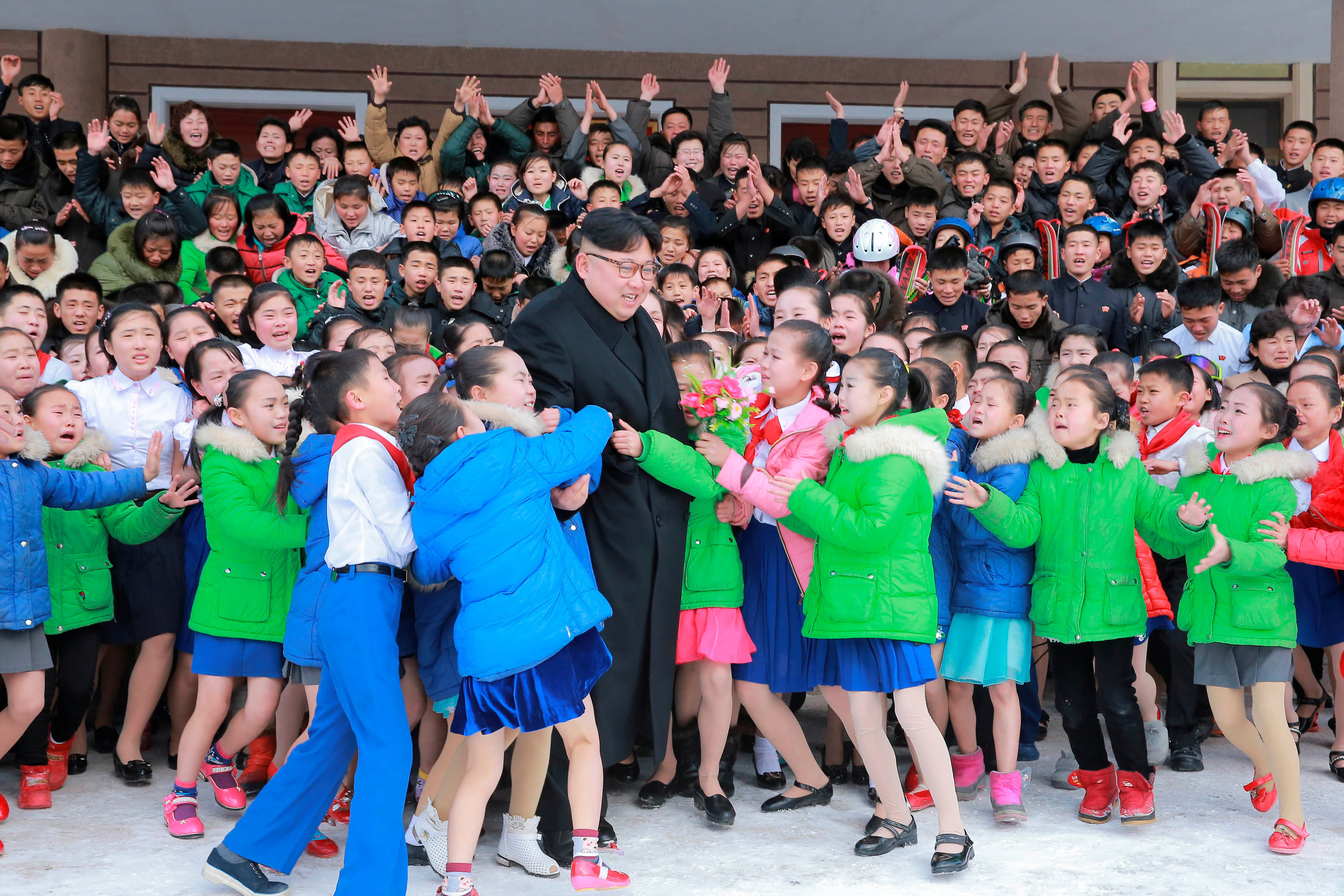North Korean leader Kim Jong Un is hugged by children during his visit to Samjiyon County