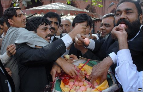 Lawyers grab colourful sweets in the street