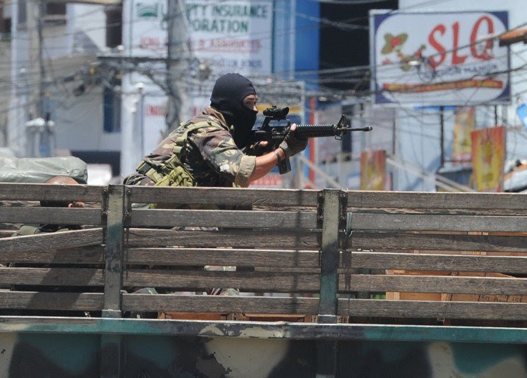 TAKING AIM. A soldier on board a truck aims his weapon towards rebel positions as the stand-off between the two sides enters its sixth day in Zamboanga on September 14, 2013. AFP/Ted Aljibe