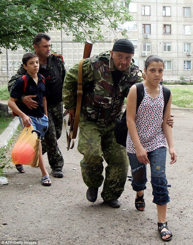 Pro-Russia militants evacuate the children living in nearby apartments during the shoot-out