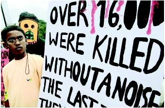 This boy is looking at a Greenpeace poster, which expresses solidarity for the victims of the Union Carbide chemical disaster in Bhopal, India, eighteen years after  the incident. (Photograph  by Indranil Mukherjee. © AFP/Corbis. Reproduced by permission.)