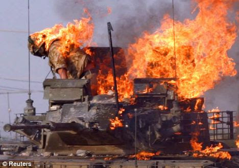 Mopping up: British soldier prepares to jump from a burning tank which was set ablaze in Basra 