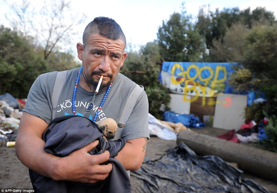 Defiant: Valentine Cortes, a journeyman construction worker pictured with a 6-week-old puppy in his hands, said he had no plans to leave his makeshift shelter