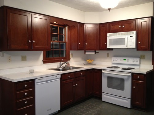 Brown cabinets, white corian countertop w white appliances