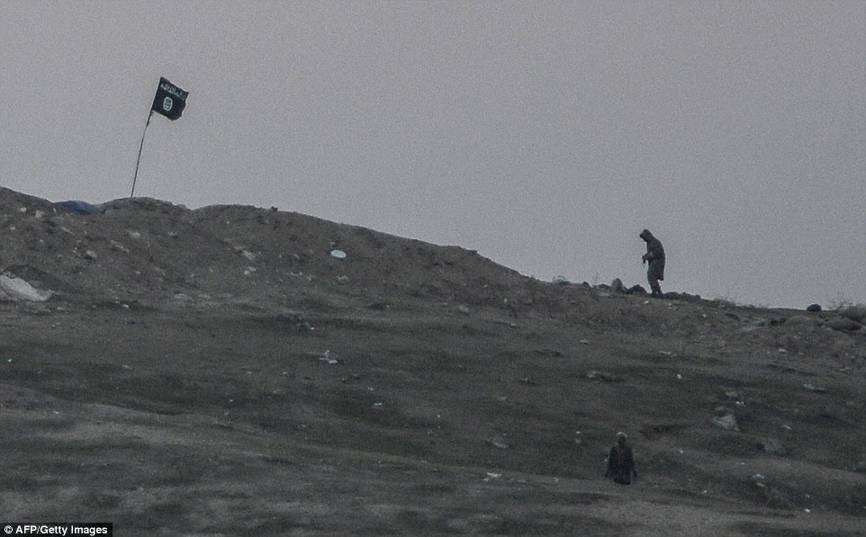 The Islamic State's black jihadist flag has been obliterated in a devastating airstrike by American forces on a Kobane hillside controlled by the militant group. Islamic State (IS) jihadist are seen just before the launch of an air strike  on Tilsehir hill near Turkish border