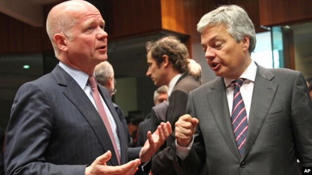 Ngoại trưởng Bỉ Didier Reynders (phải) và Ngoại trưởng Anh William Hague dự hội nghị ở Brussels, Bỉ