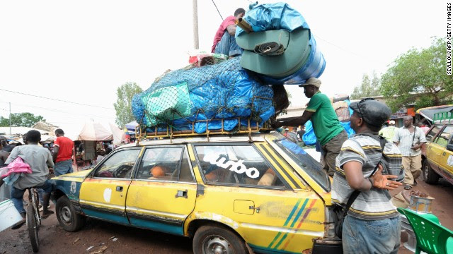 After an Ebola case was confirmed in Senegal, people load cars with household items as they prepare to cross into Guinea from the border town of Diaobe, Senegal, on Wednesday, September 3.