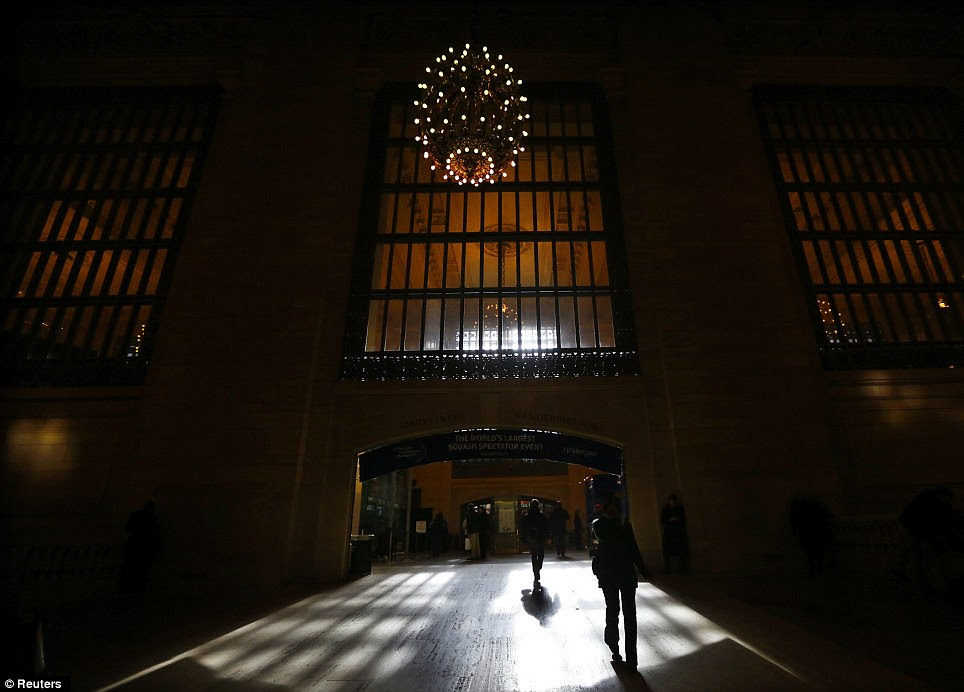 Light shines through a window as commuters enter the main concourse 