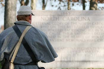 A North Carolina reenactor pauses to think about the soldier he is portraying by the North Carolina Memorial during Remembrance Day in Gettysburg, PA.  © Mike Lynaugh