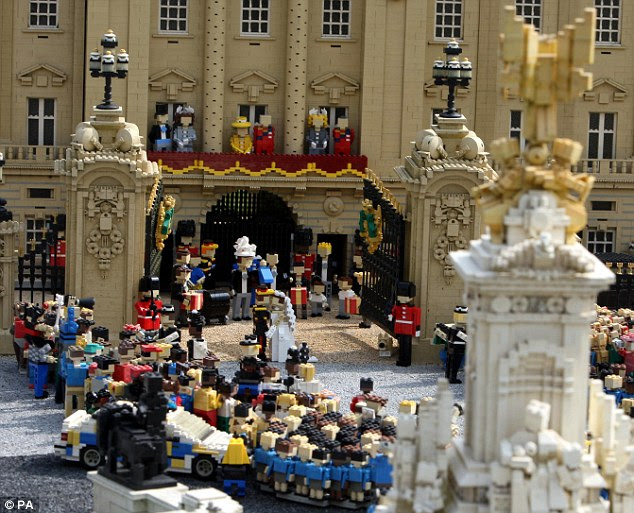 Completing the scene: While the couple kiss, wedding guests wait patiently behind them and crowds of well-wishers stand outside the gate