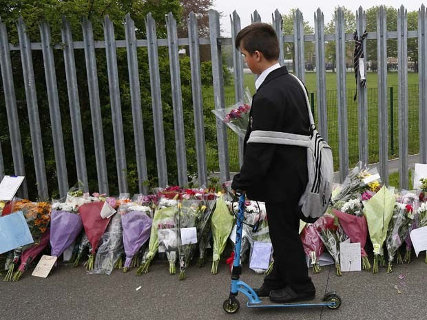 Aluno deixa flor em grade da escola em tributo a professora Anne Maguire, morta por estaudante do Corpus Christi Catholic College em Leeds (Foto: REUTERS/Darren Staples)