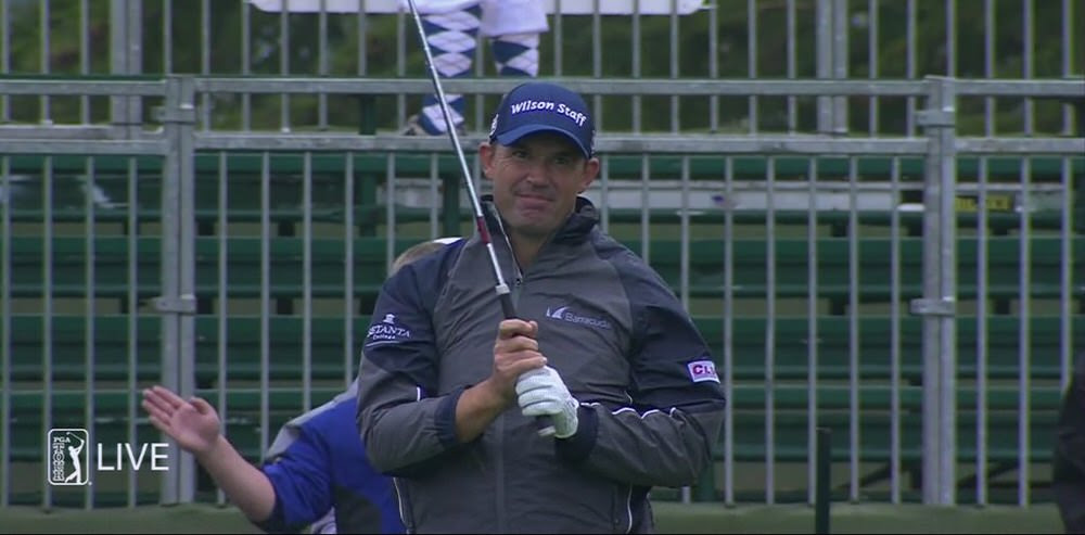 Pádraig Harrington watches as his tee shot comes up 15 yards short of the green at the 17th