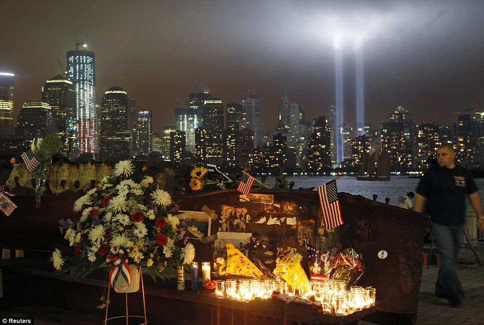 In loving memory: A man walks past a memorial as the 'Tribute in Lights' illuminates the sky over lower Manhattan on the 10th anniversary of the 9/11 attacks on the World Trade Center in New York 