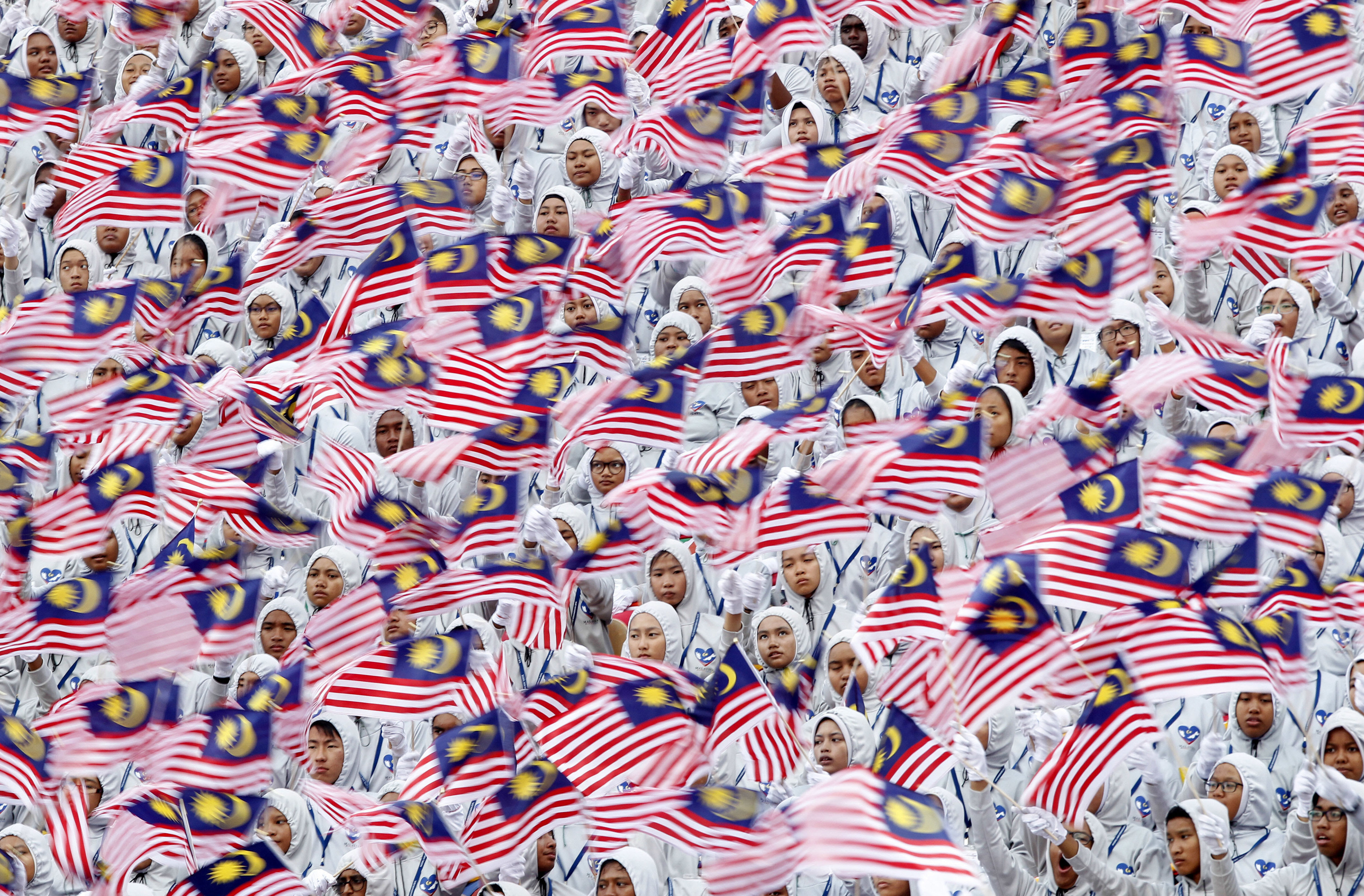 Students wave the Malaysian flag during the 59th National Day celebrations at the Independence Square in Kuala Lumpur, Malaysia, on Wednesday,